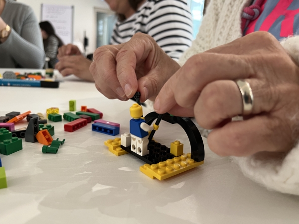 Hände, die Lego bauen, firmenjubiläum competence on top